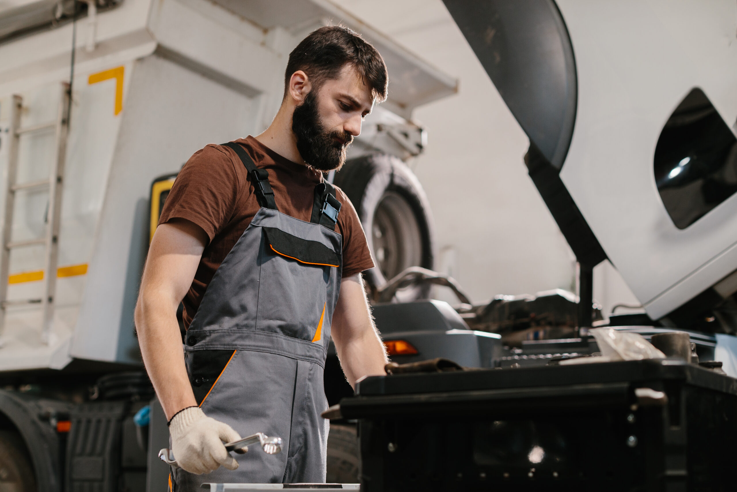 Mechanic repairing truck engine in garage workshop