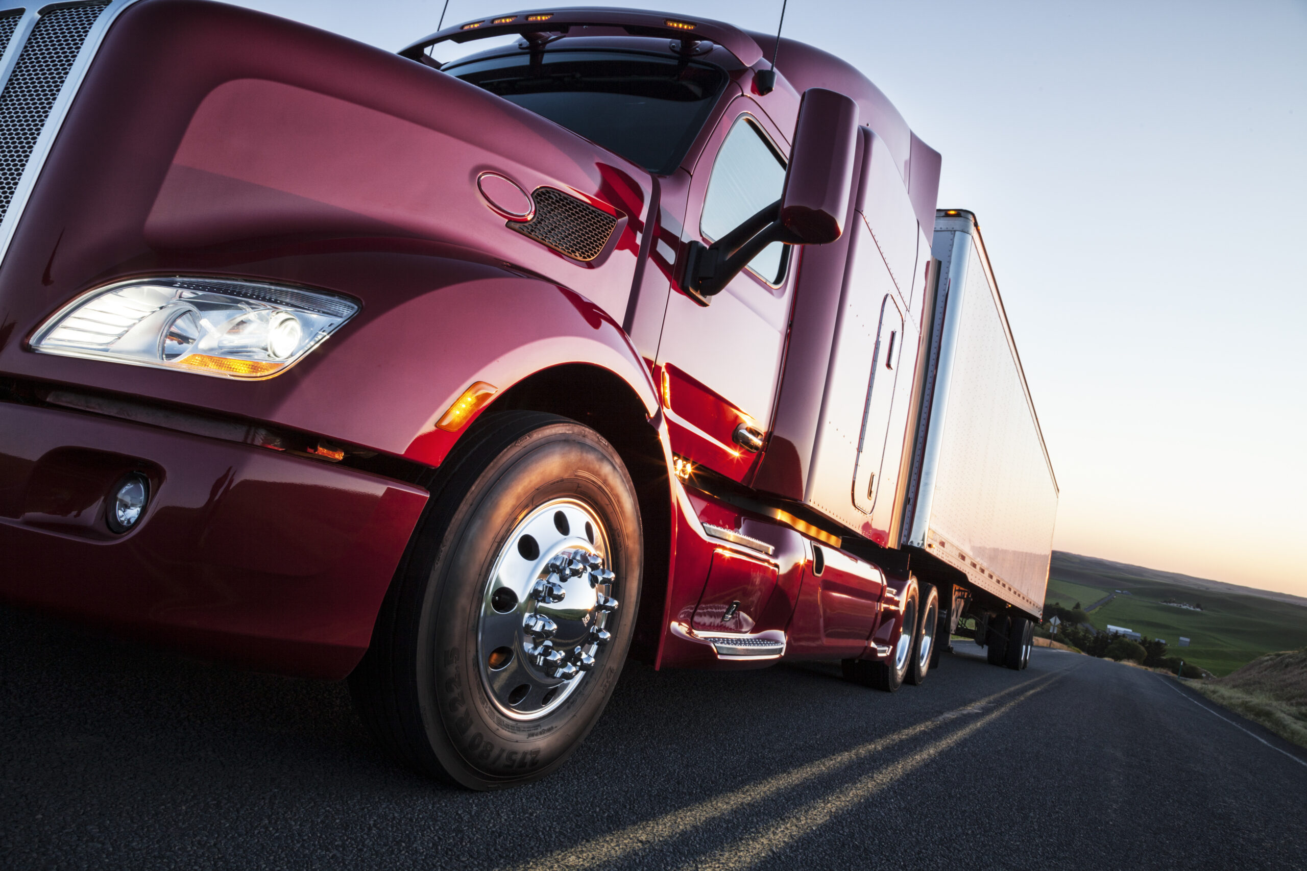 Front to rear low angle view of the cab of a commercial truck on the highway late in the day.